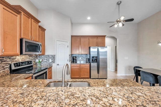 kitchen with decorative backsplash, appliances with stainless steel finishes, ceiling fan, and sink