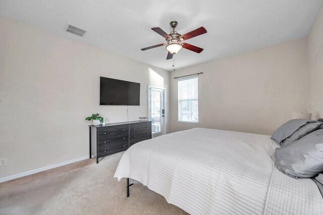 bedroom with ceiling fan and light colored carpet