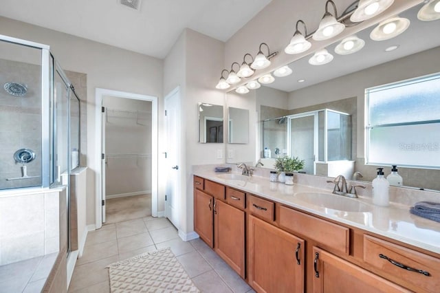 bathroom featuring tile patterned flooring, vanity, and an enclosed shower