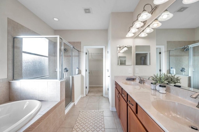 bathroom featuring tile patterned flooring, vanity, and shower with separate bathtub