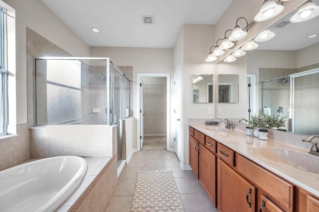 bathroom with shower with separate bathtub, vanity, and tile patterned floors