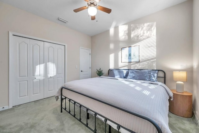 bedroom featuring ceiling fan, light colored carpet, and a closet