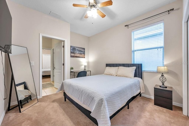 carpeted bedroom with ceiling fan and ensuite bath