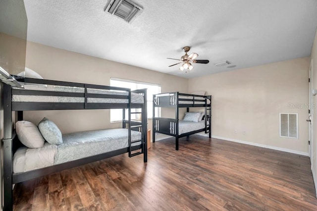 bedroom featuring ceiling fan, dark wood-type flooring, and a textured ceiling