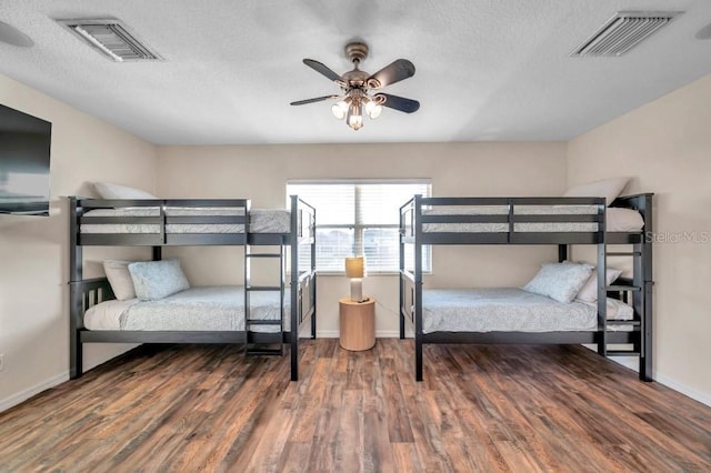 bedroom featuring ceiling fan, wood-type flooring, and a textured ceiling