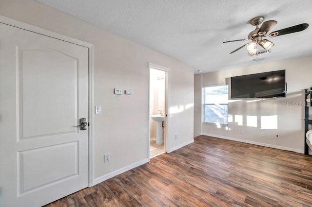 unfurnished living room with a textured ceiling, ceiling fan, sink, and dark wood-type flooring