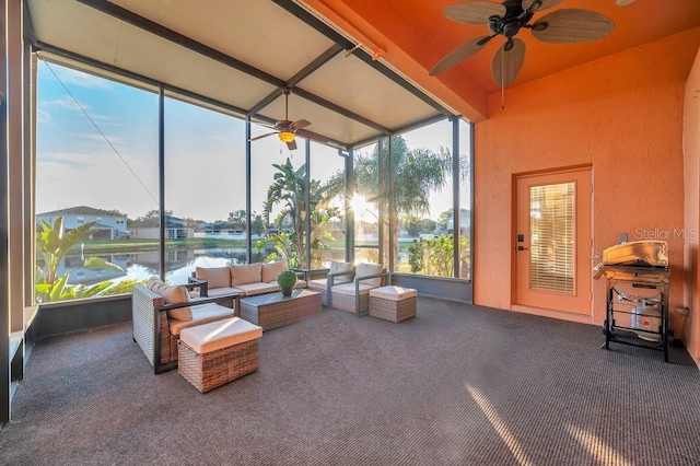 sunroom with beamed ceiling, ceiling fan, and a water view