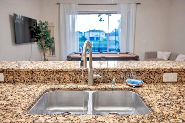 room details featuring light stone countertops and sink