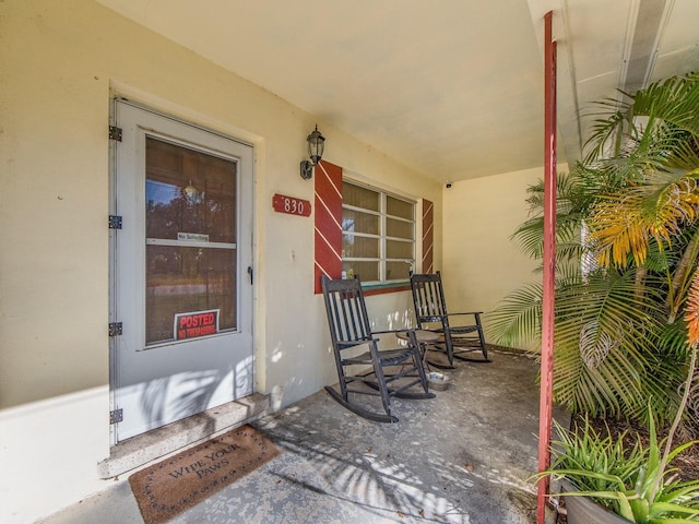 view of exterior entry featuring covered porch