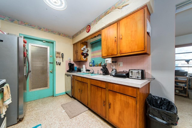 kitchen featuring backsplash, stainless steel appliances, and sink