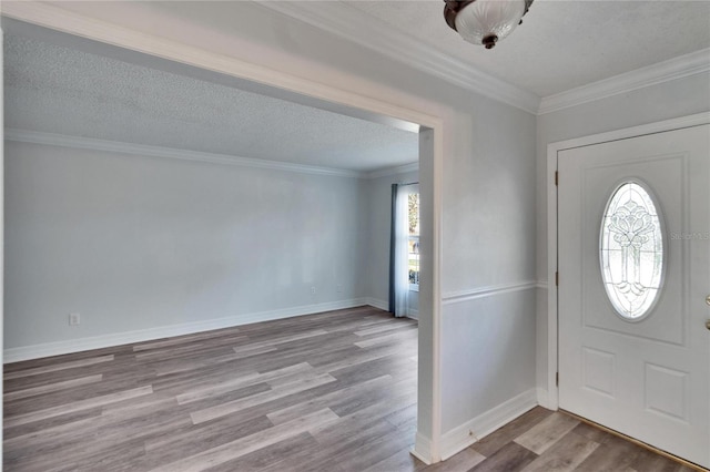 foyer entrance featuring crown molding, plenty of natural light, a textured ceiling, and light wood-type flooring