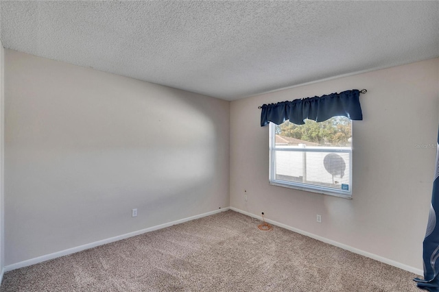 carpeted empty room featuring a textured ceiling