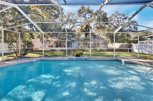 view of swimming pool featuring a lawn and glass enclosure