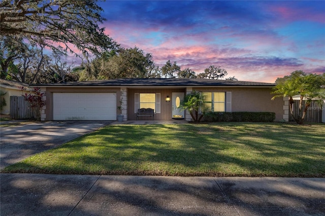 ranch-style house featuring a yard and a garage