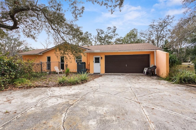 single story home featuring central AC and a garage