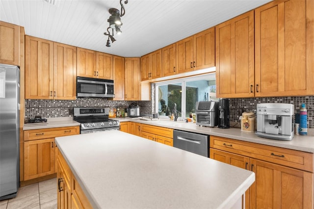 kitchen featuring decorative backsplash, light tile patterned floors, stainless steel appliances, and sink