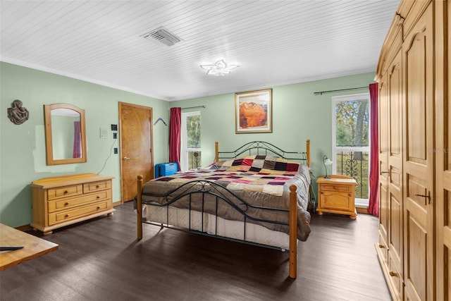 bedroom with multiple windows, a closet, dark wood-type flooring, and ornamental molding