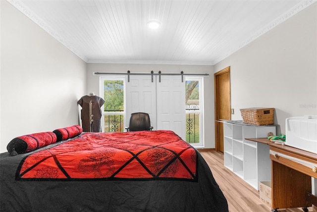 bedroom featuring multiple windows, crown molding, and light wood-type flooring