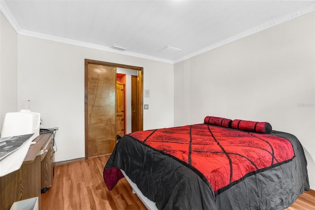 bedroom with light hardwood / wood-style floors and ornamental molding