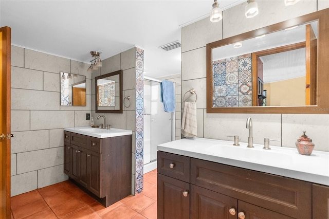 bathroom featuring an enclosed shower, vanity, tile patterned floors, and tile walls