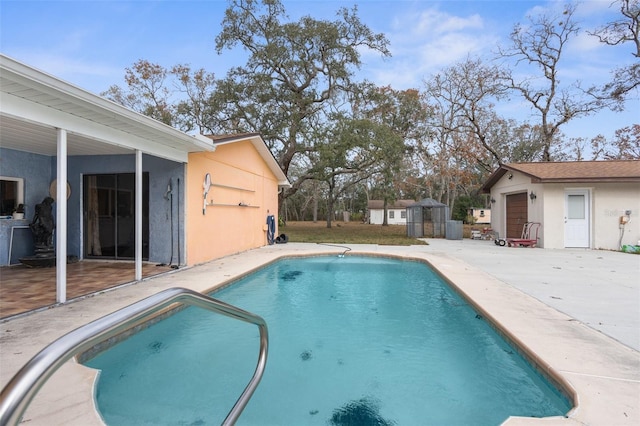 view of swimming pool featuring a patio and an outdoor structure