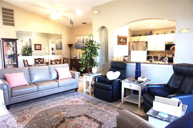 tiled living room featuring vaulted ceiling