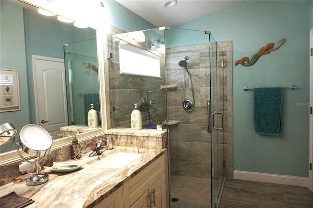 bathroom featuring vanity and a shower with door