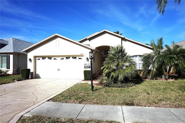 11021 Edge Park Dr, Hudson, FL 34667 - ranch-style home with stucco siding, a garage, concrete driveway, and a front yard