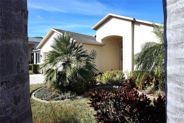 11021 Edge Park Dr, Hudson, FL 34667 - view of side of property with stucco siding and roof with shingles
