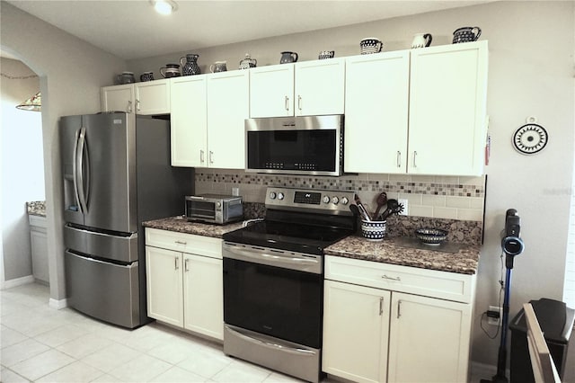 11021 Edge Park Dr, Hudson, FL 34667 - kitchen with appliances with stainless steel finishes, backsplash, arched walkways, and dark stone countertops