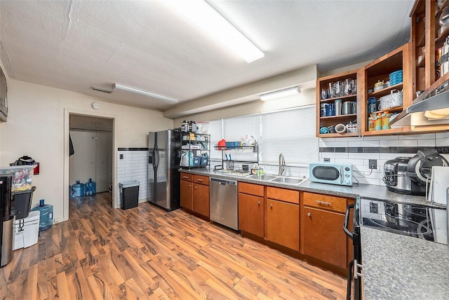 kitchen featuring sink, dark wood-type flooring, stainless steel appliances, a textured ceiling, and decorative backsplash