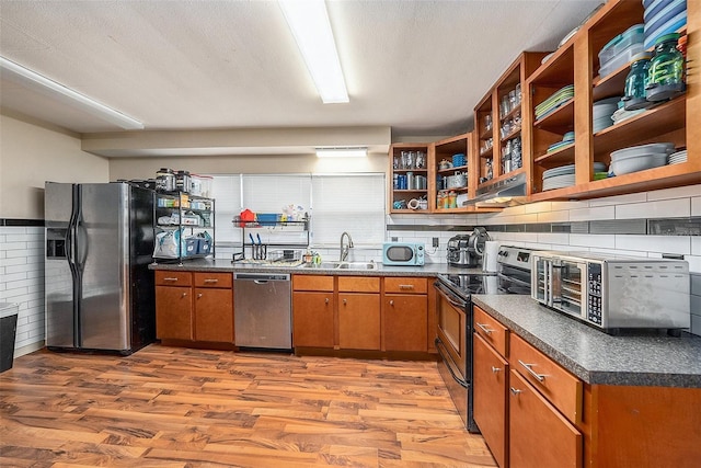 kitchen with backsplash, light hardwood / wood-style floors, sink, and stainless steel appliances