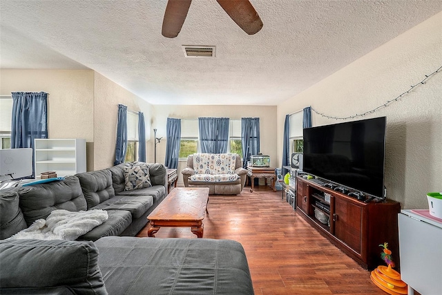 living room with ceiling fan, hardwood / wood-style floors, and a textured ceiling