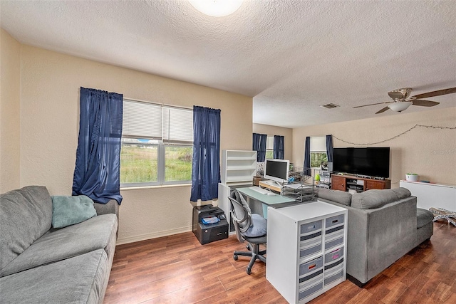 home office featuring ceiling fan, dark hardwood / wood-style flooring, and a textured ceiling