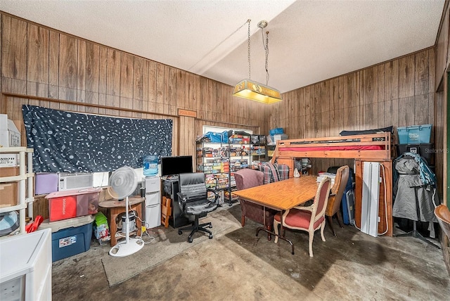 office area featuring wood walls and concrete floors