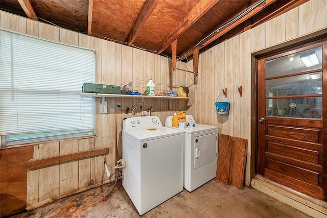 washroom with wood walls and washing machine and dryer