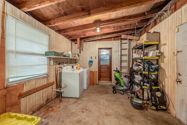 laundry area with separate washer and dryer and wooden walls