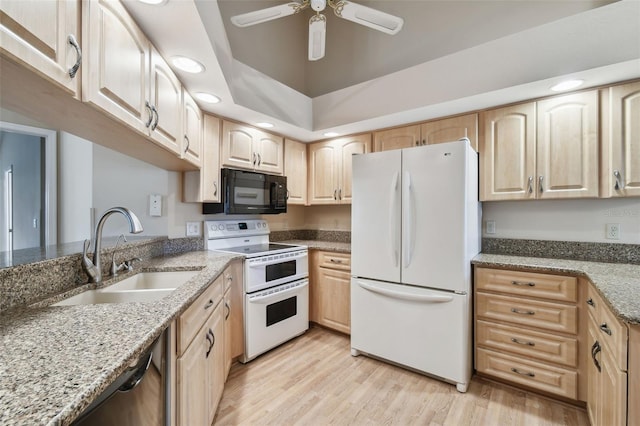 kitchen featuring white appliances, light brown cabinetry, light stone countertops, and sink