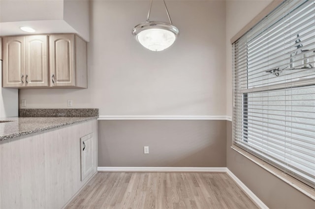 kitchen with light stone countertops, light wood-type flooring, and light brown cabinets