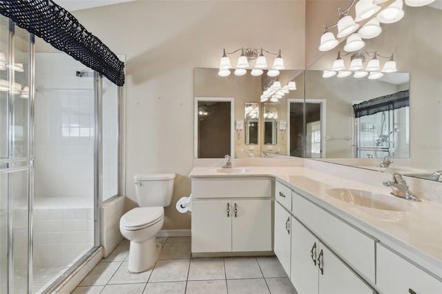 bathroom featuring toilet, a shower with door, vanity, and tile patterned floors