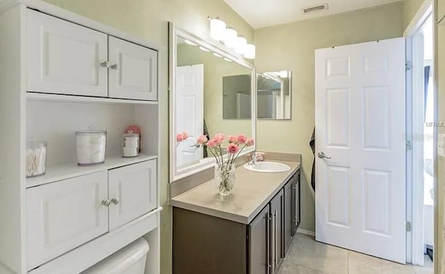 bathroom with tile patterned flooring, vanity, and toilet