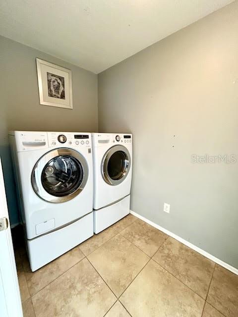 laundry room featuring light tile patterned floors and separate washer and dryer