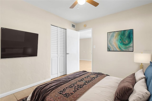 tiled bedroom featuring ceiling fan and a closet