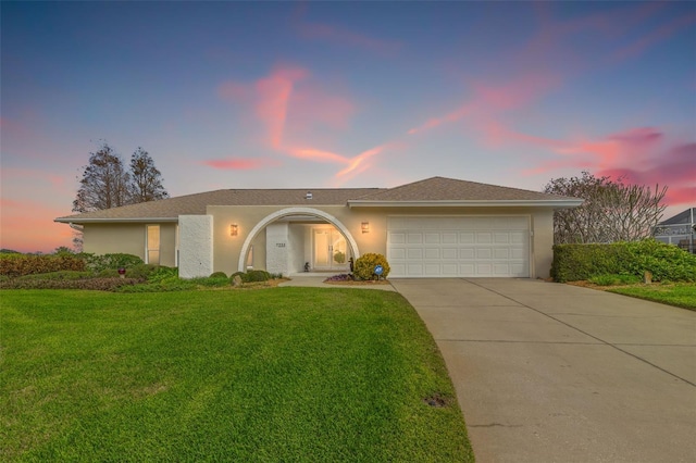 view of front of home featuring a garage and a lawn