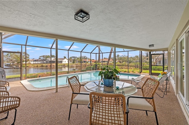 exterior space with a lanai, a patio area, and a water view