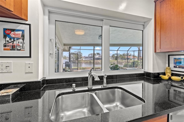 kitchen featuring dark stone counters and sink