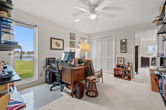 carpeted office with ceiling fan and a textured ceiling