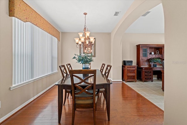 dining room featuring plenty of natural light, wood-type flooring, and a chandelier