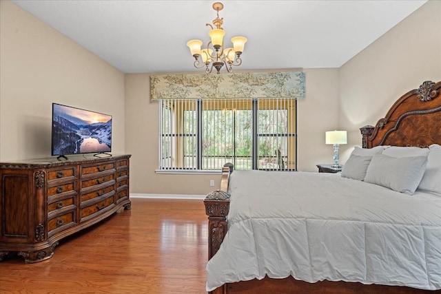 bedroom featuring hardwood / wood-style flooring and an inviting chandelier