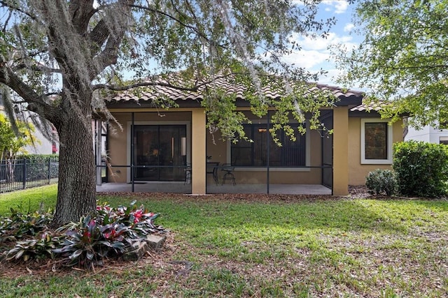 back of house featuring a yard and a sunroom